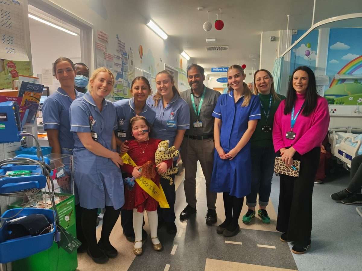 Lilyana ringing the bell with hospital ward staff