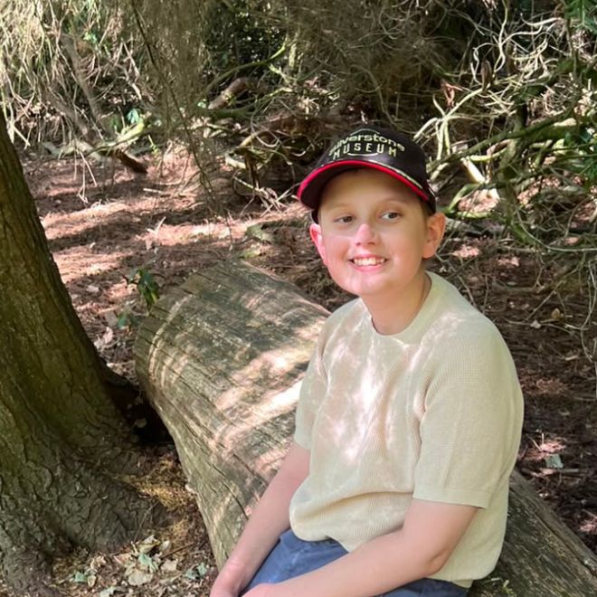 A child sat on a tree trunk